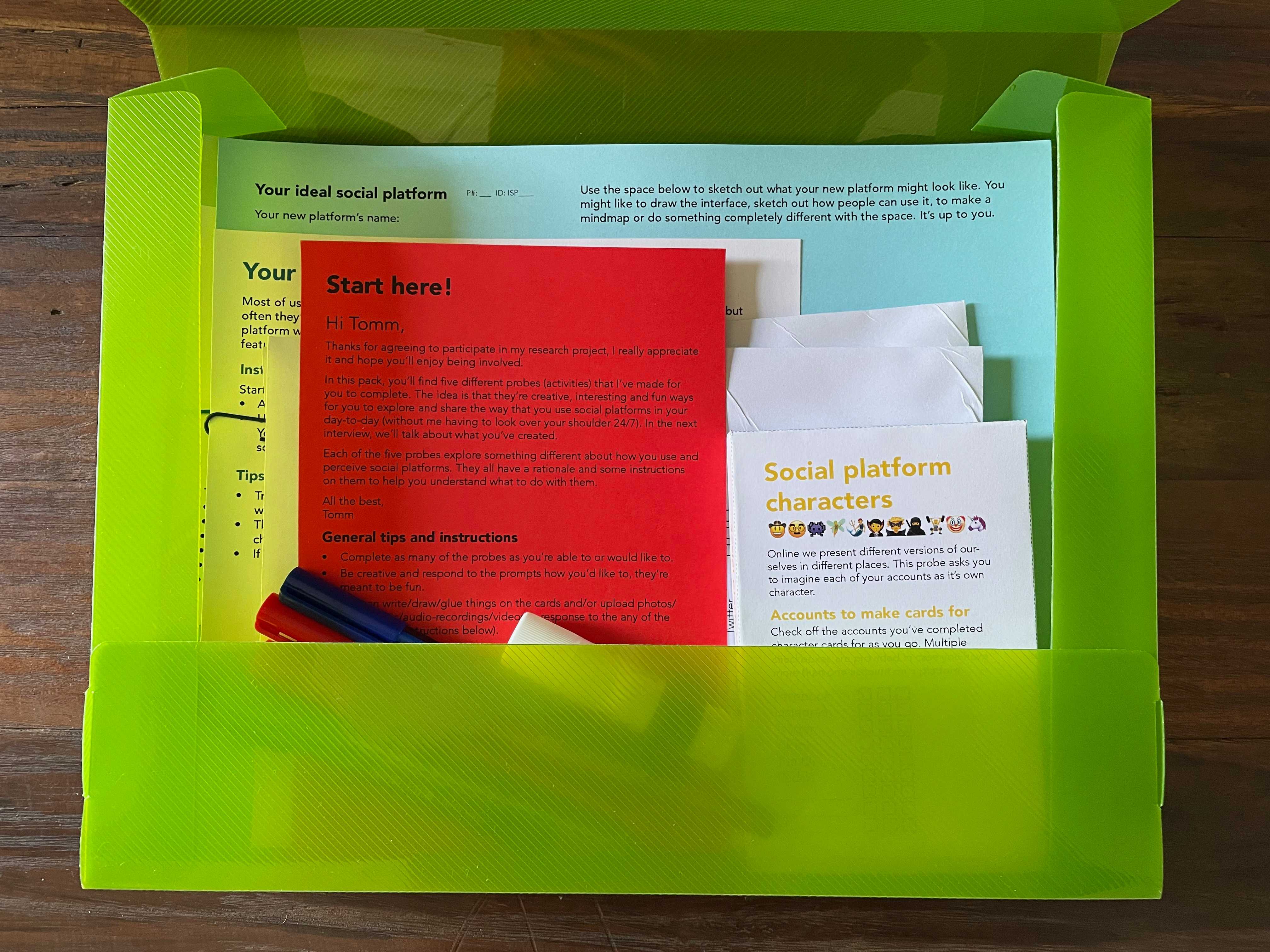 A plastic box full of paper based activities and pens.